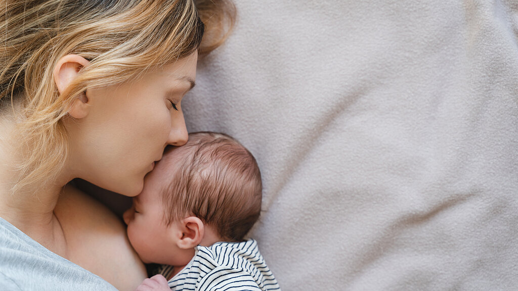 Mother breastfeeding baby. Baby eating mother's milk.