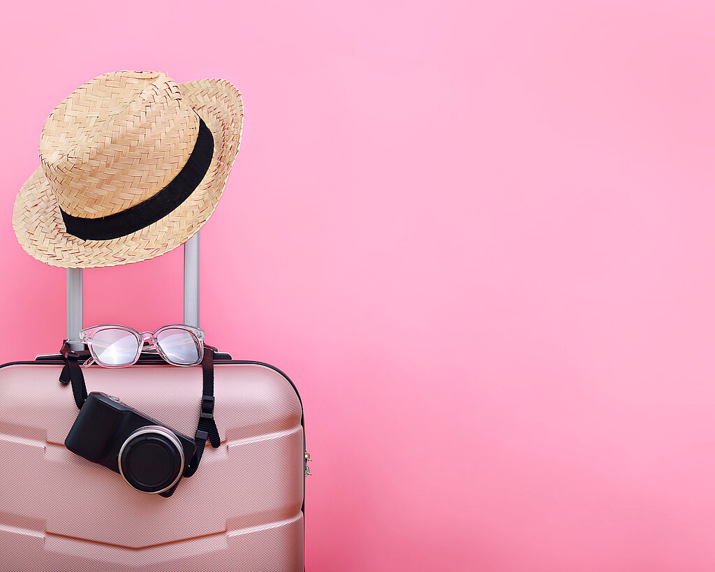 Luggage With Hat Against Pink Background