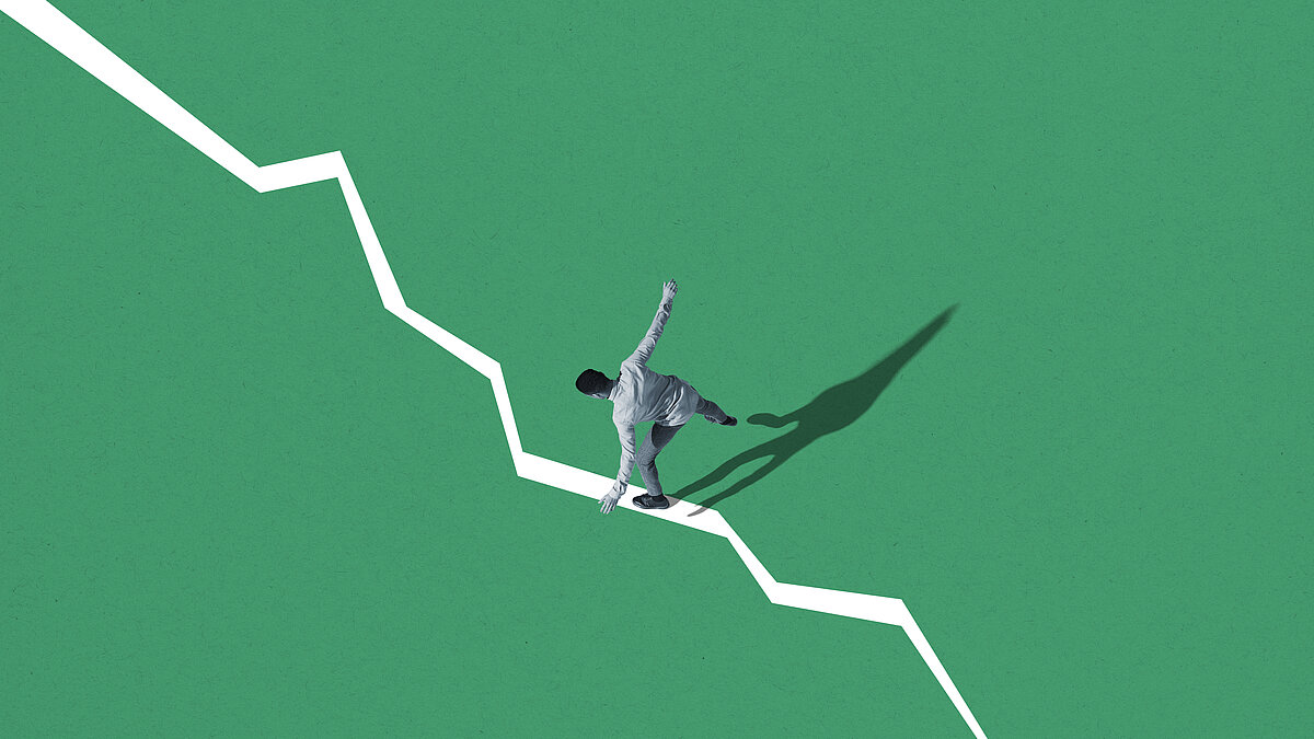 Young man balancing himself on two tone background