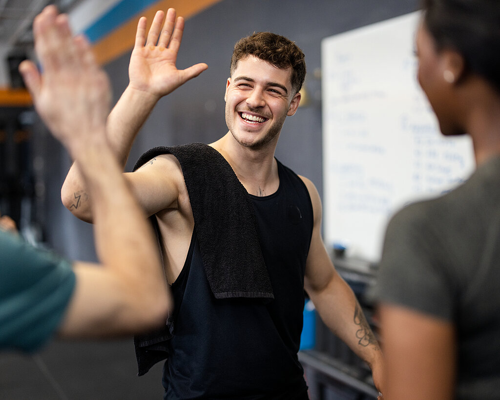 Erfolgreiches Training und High-Five im Fitnessstudio