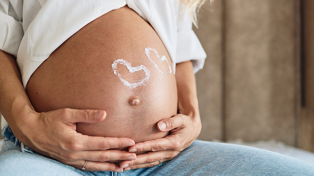 Pregnant woman embracing her belly