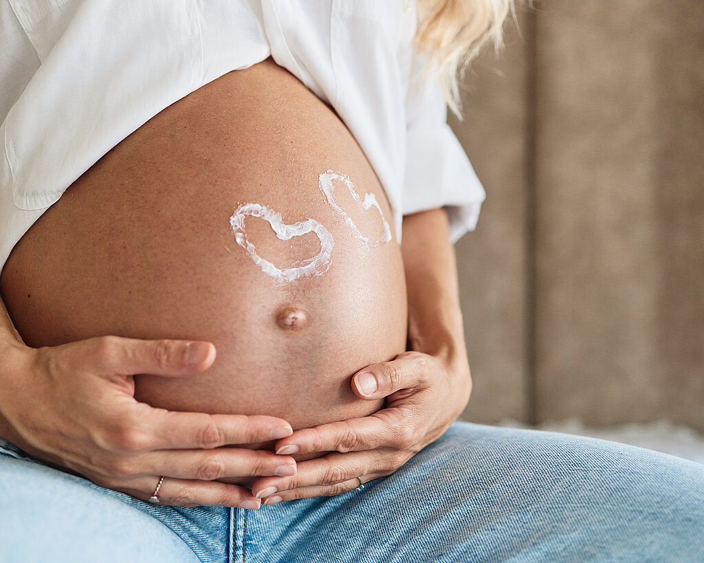 Pregnant woman embracing her belly