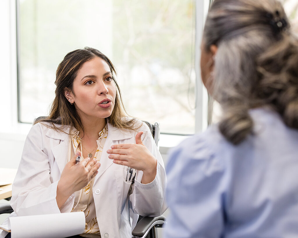 Mid adult female doctor gestures while explaining her recommendation to the patient