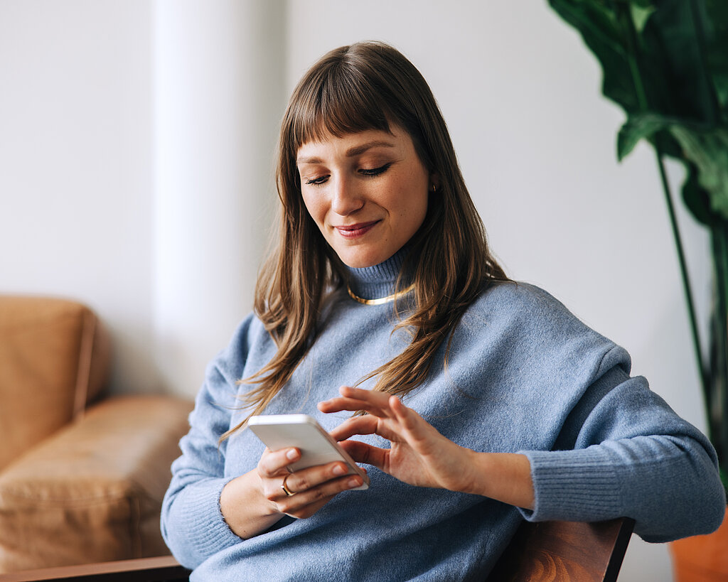 Businesswoman using a mobile phone in an office lobby