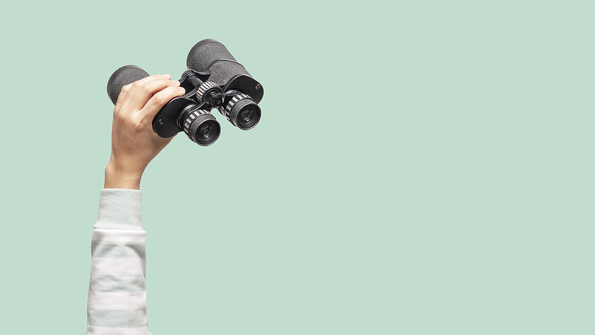 Woman with binoculars on green background