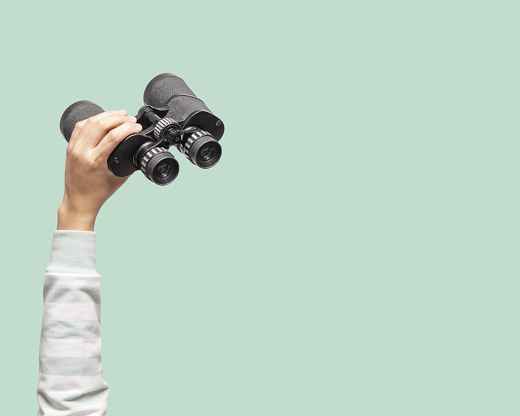 Woman with binoculars on green background