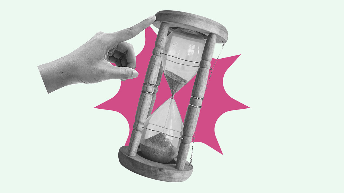 Hand pointing and pushing hourglass with sand falling, running out of time concept