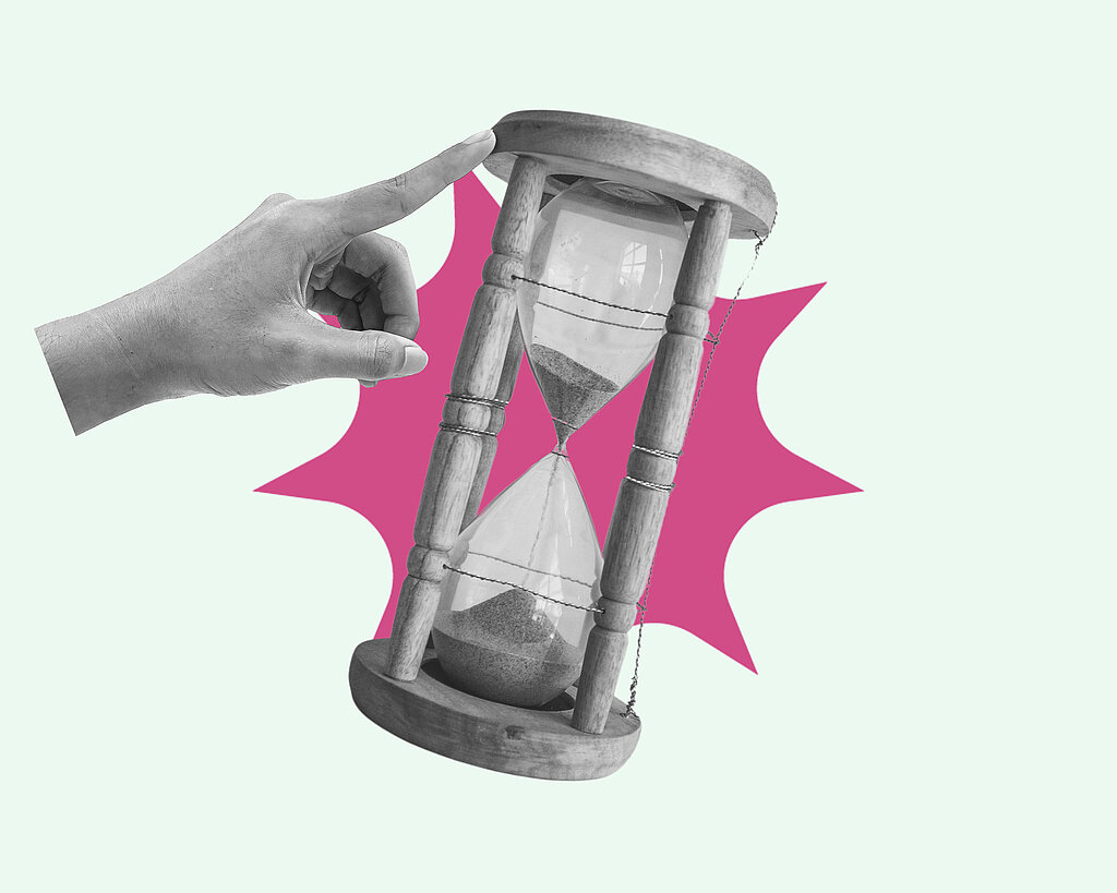 Hand pointing and pushing hourglass with sand falling, running out of time concept