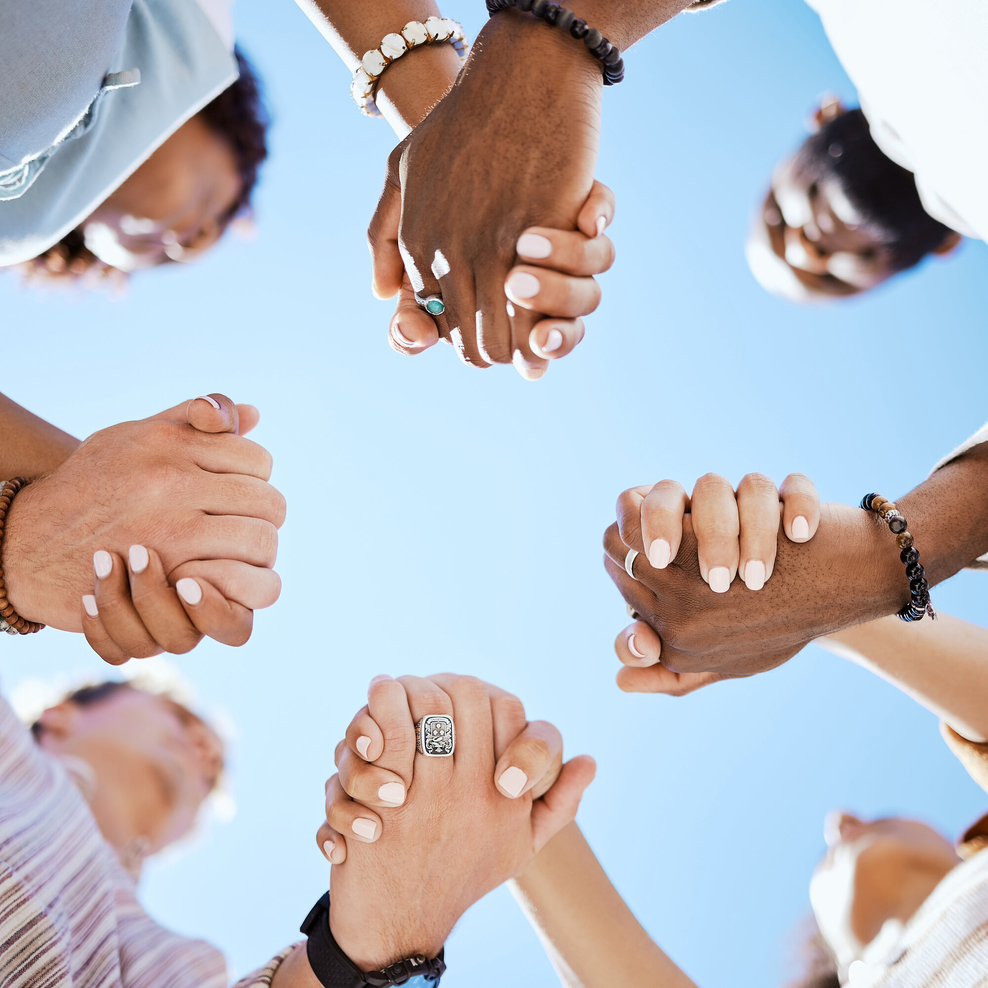 Diversity, support and people holding hands in trust and unity for community against sky background. Hand of diverse group in solidarity for united team building collaboration and teamwork success