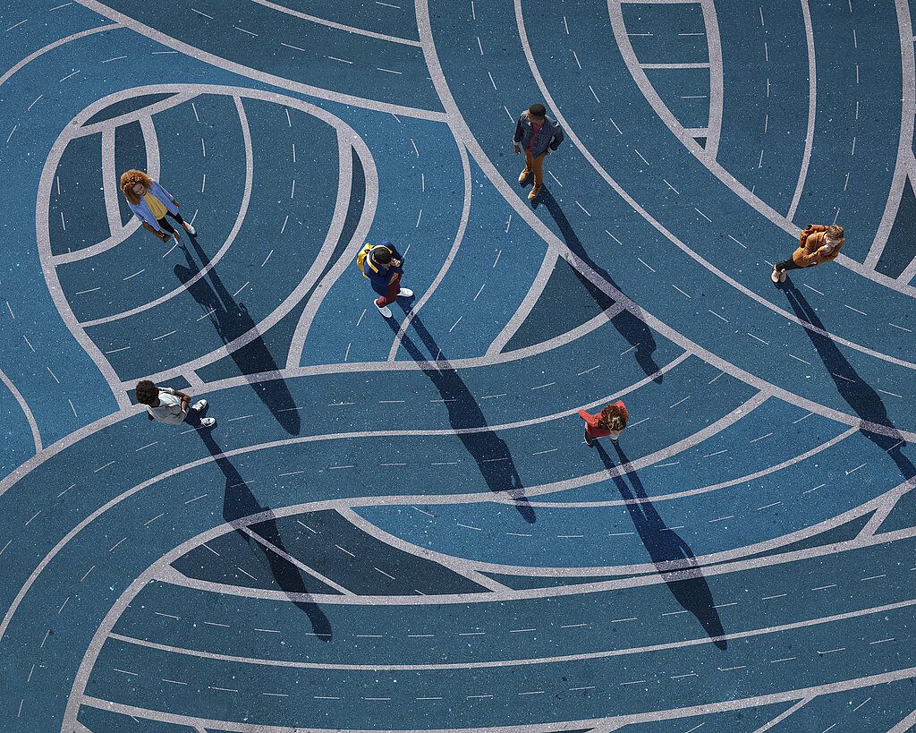 Group of people standing on different curvy roads, painted on asphalt