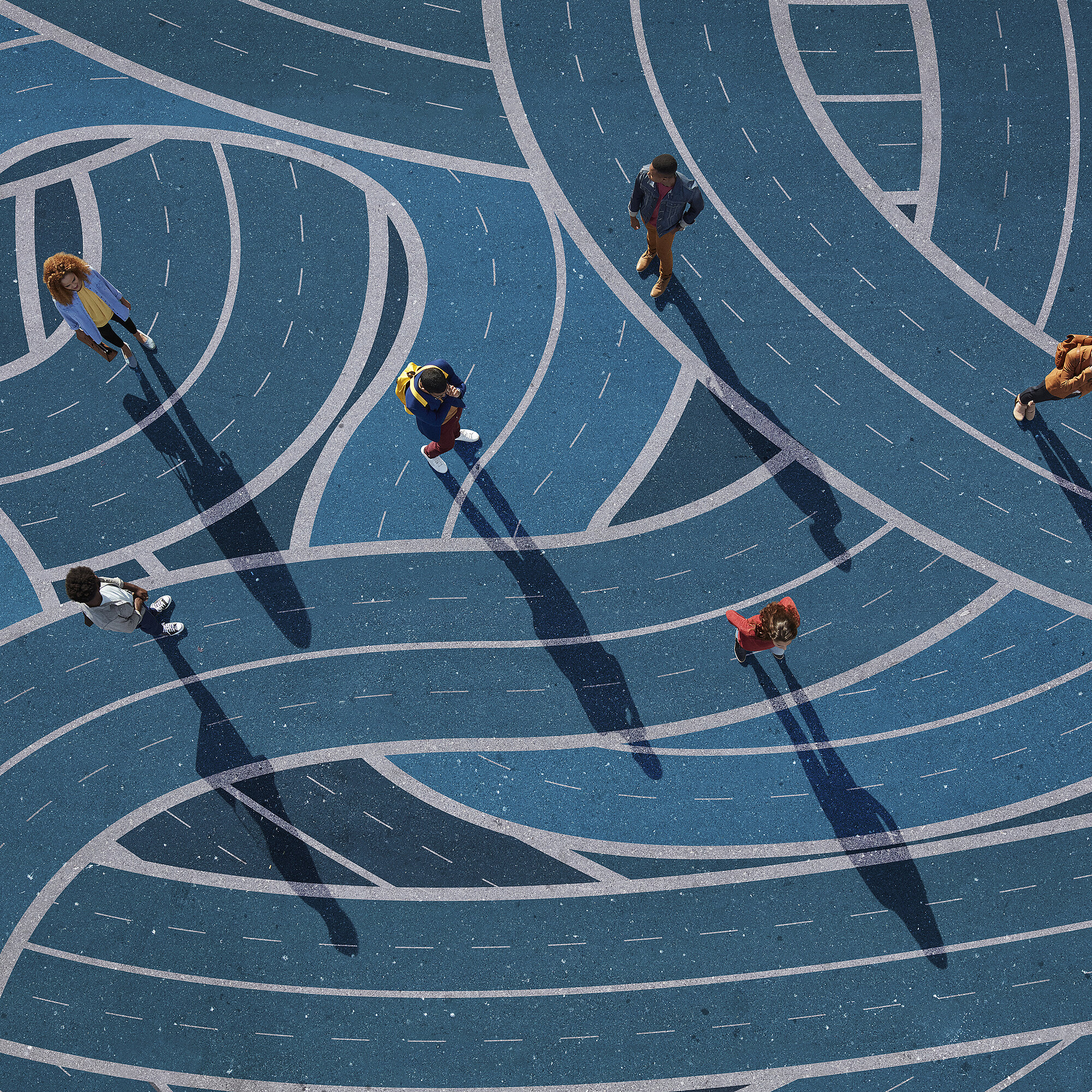 Group of people standing on different curvy roads, painted on asphalt