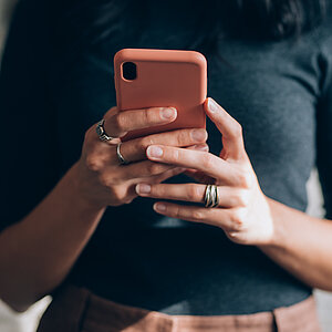 Unrecognizable Female Office Worker Using a Smartphone in the Office